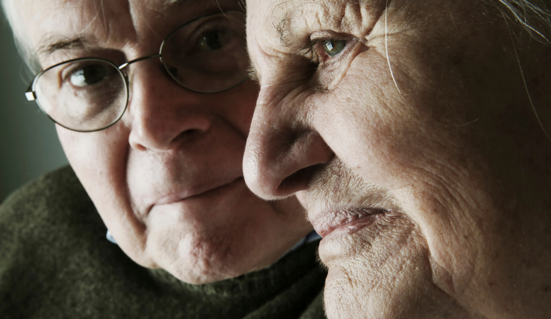 A close-up of an elderly man and women