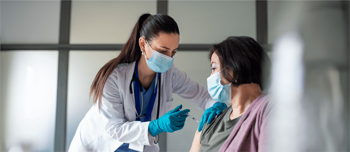 Photo of a doctor administrating vaccine to a patient.